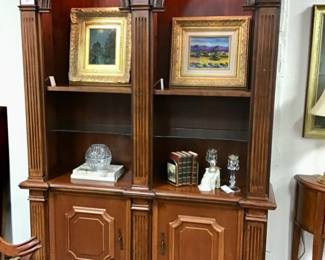 Architectural double arched cherry bookcase with shaped glass and wooden shelves. Fluted columns, brass hardware.