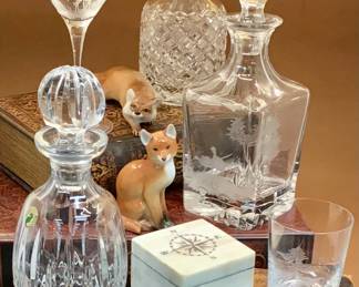Crystal decanters and glassware by Scully and Scully, Waterford, antique English cut glass. Porcelain foxes. 