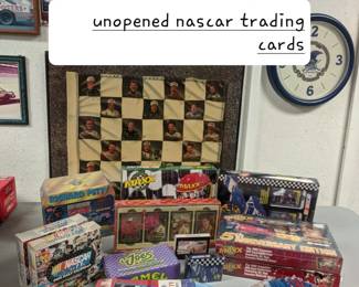 Unopened packages and full case boxes of Nascar trading cards.