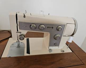 Kenmore sewing machine in cabinet with attachments