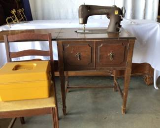 Vintage Montgomery Ward sewing machine in cabinet with chair & sewing box. $50