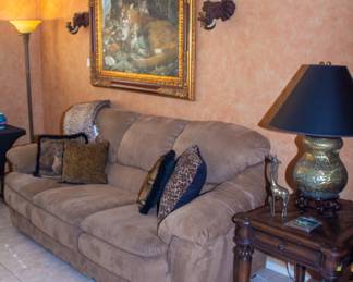 Plush upholstered couch, Tiger artwork, Elephant shaped sconces 