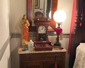 Not sure I got all the details but the mirror is an Empire mahogany, a marble top walnut Eastlake small table, one of many electrified oil lamps, Eastlake clock and Jesus's sacred heart.