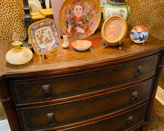 Figural leather top three drawer chest and notice the pretty porcelain figurines and plates including a Hibel