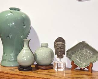 An iron Buddha bust hovering over acrylic stand