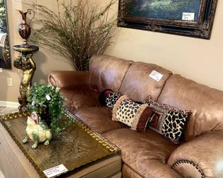 Look at this cushy leather sofa!  The cloth ottoman opens for great storage and is topped off with a huge brass tray.