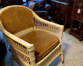 Antique wicker chair with velvet cushions.