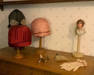 Decorative antique pieces including glove stretcher and vintage hats. 