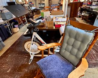 Schwinn exercise bike and one of three wood rockers.