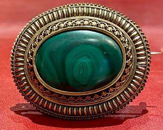 $1800 - a fine 15k yellow gold English brooch (circa 1860) with oval shaped Russian Malachite stone. The Malachite is enhanced in a gold frame with concentric circles of Etruscan style work. Intact locket with original glass and pin and clasp - Purchase certificate by Dixon and Dixon