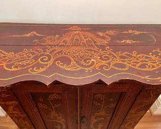 Detailed view of  $1500 - Antique, deep red, hand-painted Chinoiserie two-door wooden cabinet. Provenance; purchased from a highly respected antique dealer in New Orleans. There are a few drilled spots on the back indicating it may have been used to hold electronics at one point. 