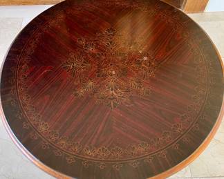 SOLD; 21"d x 27"h; round, wooden table with gold gild and cat-motif legs; close up view of intricate design on top of table