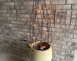 Planter with topiary strung with lighted dragonflies
