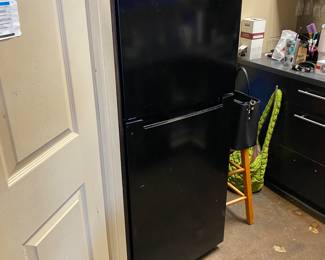 Small black refrigerator freezer used in break room.