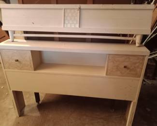Footboard is sitting on top of headboard. There is a dresser and nightstand that match this bed.