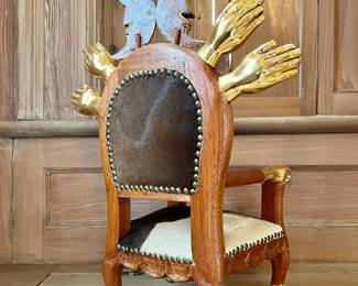 Pedro Friedeberg (Mexican, b. 1936)
Parcel gilt “throne” chair sculpture decorated with hands and crescent moons, upholstered with cow hide, signed on base