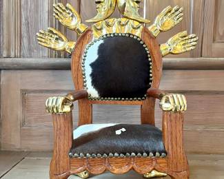 Pedro Friedeberg (Mexican, b. 1936)
Parcel gilt “throne” chair sculpture decorated with hands and crescent moons, upholstered with cow hide, signed on base