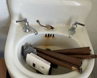 wall mounted white enamel cast iron porcelain vintage antique rounded high back sink with original faucets 
