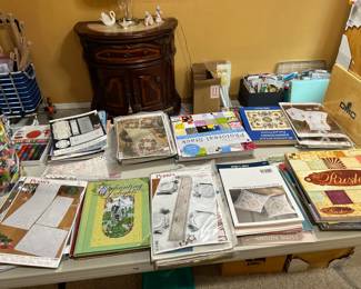 room filled with needlecraft and embroidery and scrap making books, Needlepoint magazines, Bucilla kits, embroidery, etc.