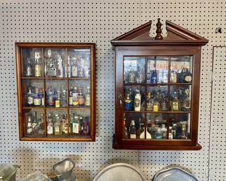 Two wooden wall cabinets with miniature bottles 