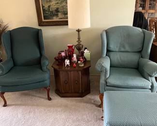 Two wingback chairs one with a matching ottoman
