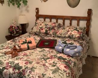 Queen size bed with headboard, underneath drawers, and bedding