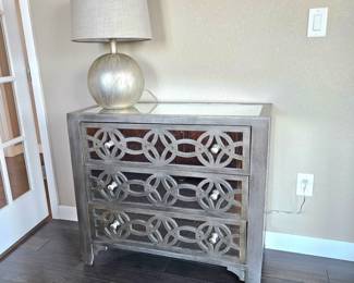 Charming Mirrored Chest of Drawers Painted in Brushed Silver Paired with Matching Round Silver Table Lamp