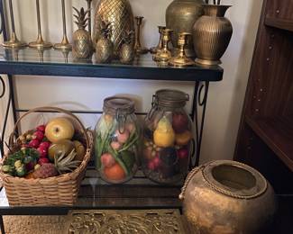 Classy brass items and not-so-classy plastic fruit stuffed in jars.