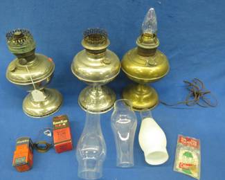 Lot 75. Three Aladdin-style lamps, one has been converted to electric. Extra wicks