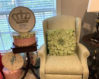 Comfy chair;  adorable pillow; darling hat boxes; vintage side table