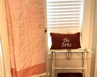 Another quilt; pillows; luggage rack; small footstool