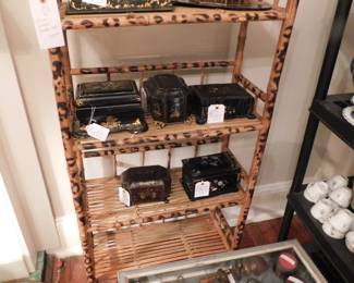Rare tea caddies sit on a burnt bamboo shelf or bookstand. 