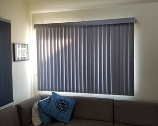 Sun-filtering shades and vertical blinds in a neutral gray throughout home