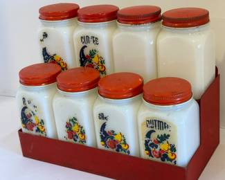 Set of Eight Milk Glass Spice Bottles in Metal Holder. Fun retro item! 

Items in used condition with some wear including paint loss. The metal holder measures about 7.75" x 4.5" x 6.25" 