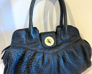 Stuart Weitzman Black Leather Handbag, looks to be new (no tags)

Features an interior zipper compartment and a zippered top enclosure. Measures about 17" x 4.5" x 11" 