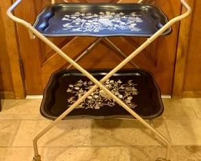 Amazing Vintage Mid Century TV Trays on a Rolling Cart! This is a must have with your mid century decor, the trays lift of the cart and are adorned with a beautiful vintage vine motif.

Measures 30" H x 28"W x 17" D.