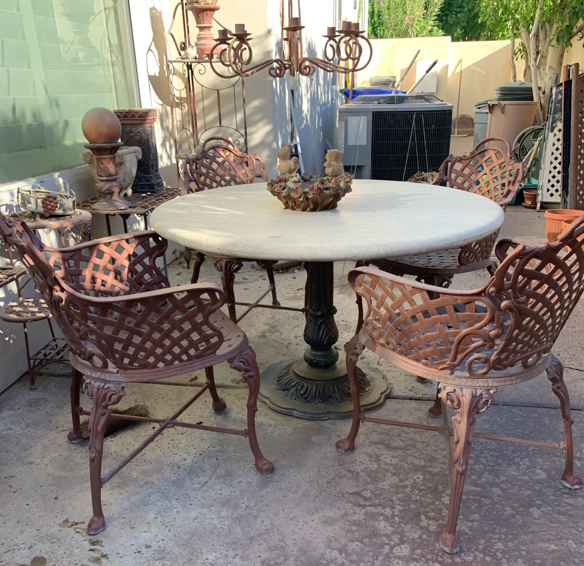 Travertine pedestal table with four woven iron chairs