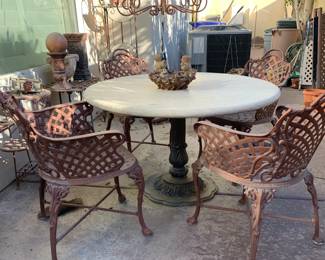 Travertine pedestal table with four woven iron chairs