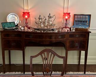Sheraton style sideboard with pink lusters and silver flatware table service