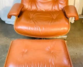 GRLE323 Charles Eames Leather Chair Ottoman Chair and Ottoman are made of chrome, leather and wood. There is a missing rivet at the base of the left arm and a foot rest at the bottom - see pics. The chair is 39' Tall x 34' Wide. There is a small hole on the ottoman by the button