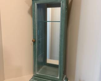 A35 - $30. Small display cabinet with 3 glass shelves. Measures 28.25” tall x 12” wide x 5.5” deep. 