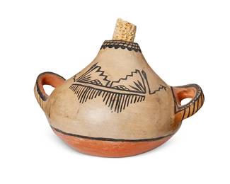 307
A Cochiti Pueblo Pottery Canteen
Early 20th century; New Mexico
Appears unmarked
The upright canteen with three-color kiva step and foliate motifs, opposed lug handles, and later added corn cob stopper
5.75" H x 8.75" W x 7" D
Estimate: $200 - $400