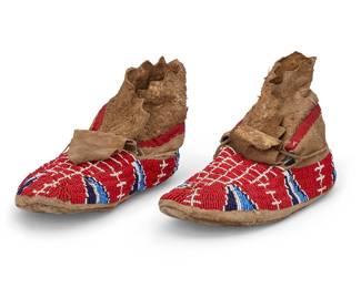 131
A Pair Of Sioux Beaded Hide Moccasins
Early 20th century; Northern/Central Plains
Beaded in red, blues, and white with geometric motif band to sides and central lattice design, with fold-over cuffs at ankles with red plain weave fabric band, 2 pieces
Each: 10.5" L x 4" H x 4" W approximately
Estimate: $400 - $600