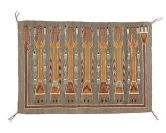 113
A Navajo Yei Pictorial Textile
Mid-20th century, Diné
Woven by Wellen Bitsie in cream, grey, brown, tan, and ochre wool with seven standing Yei figures surrounded by a Guardian figure
31.5" H x 46" W
Estimate: $500 - $700