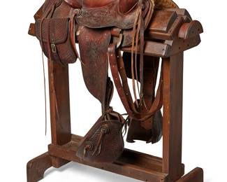 9
A Tooled Leather Western Ranch Saddle
Mid/late 20th century
Marked to one strap: U8
A leather saddle with thick monogrammed horn and tooled pommel, with a set of saddle bags, various attachment straps including decorative rosettes and lacing straps, and elaborate tooled leather fenders and stirrup covers, with a sheepskin lining
Overall: 14" H x 19" W x 25" D; seat size: 17"; gullet: 15" W; swell: 4.5" H x 16.5" W
Estimate: $800 - $1,200