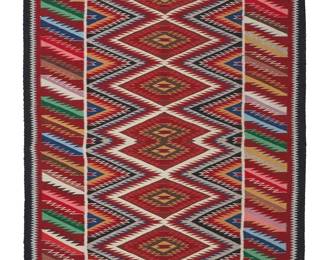 161
A Navajo Regional Rug
Mid/late 20th century, Diné
Woven in multiple colors such as red, black, cream, blue, yellow, and pink wool in an all-over eyedazzler pattern with sawtooth diamonds and diagonal motifs with an elaborate border
60" H x 39.25" W
Estimate: $400 - $600