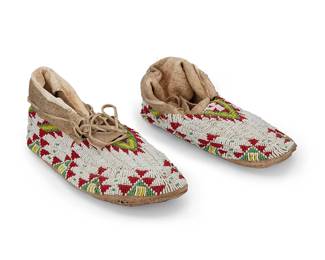 133
A Pair Of Sioux Beaded Hide Moccasins
Early 20th century; Northern/Central Plains
Each beaded in red, green, yellow, and white with sawtooth diamonds and other geometric motifs, with fold-over hide cuffs at ankles and hair-on-hide soles, 2 pieces
Each: 10.25" L x 4" H x 3.25"-4" W approximately
Estimate: $300 - $500
