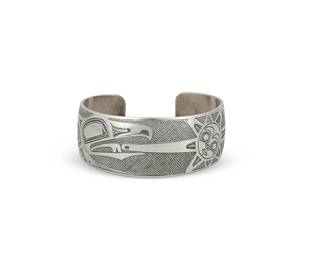 69
Danny Dennis (1951-2012, Gitksan)
A Northwest Coast silver cuff bracelet, late 20th/early 21st century
Stamped: D. Dennis / © Metal Arts / Sterling / Made in USA
A sterling silver cuff with engraved raven and sun motif
7.25" total inner C x 1.125" H, wit ha 1" gap
63.2 grams
Estimate: $200 - $300