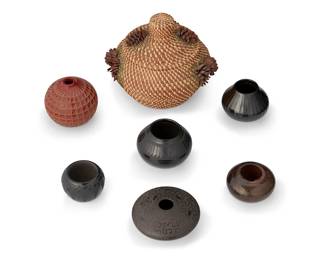 334
A Mixed Group Of Pottery And Basketry Vessels
Mid/late 20th century
Seven works:

Tamalyn "Tammy" Tarbell (b. 20th century; Haudenosaunee, Kanien'kehá'ka (Mohawk) Nation, New York)
A small burnished brownware pottery bowl, circa 1989
Signed and dated to base Tarbell / 89
A low globular bowl with textured rim and fire clouding
2" H x 3.625" Dia.

Six further works including a large lidded coiled pine needle basket with applied pine cone accents (8" H x 8" Dia.), a Nicaraguan redware pottery jar with incised geometric motifs by Dina y Felipe Guiterrez (4" H x 4.25" Dia.), a Hungarian matte micaceous brownware pottery seed jar by Kaváts (2.25" H x 5" Dia.), and three Santa Clara Pueblo blackware pottery jars (largest: 3.25" H x 4.25" W; smallest: 2,25" H x 3" Dia.), 6 pieces

7 pieces total
Estimate: $100 - $200