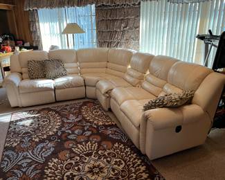 Cream leather reclining sectional and area rug